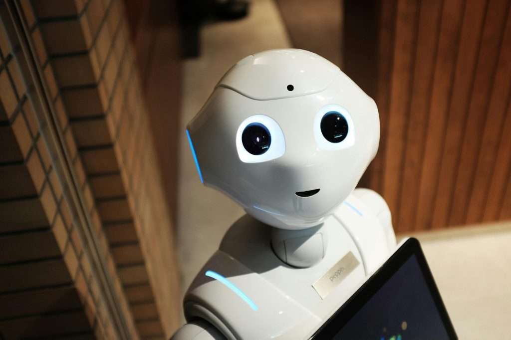 Navigating AI in the Writing Industry—Part 2: AI and Copyright 1 A stark white, cheeky-looking robot gazes at the reader. Its photoreceptors reveal a glimmer of the potential AI within.